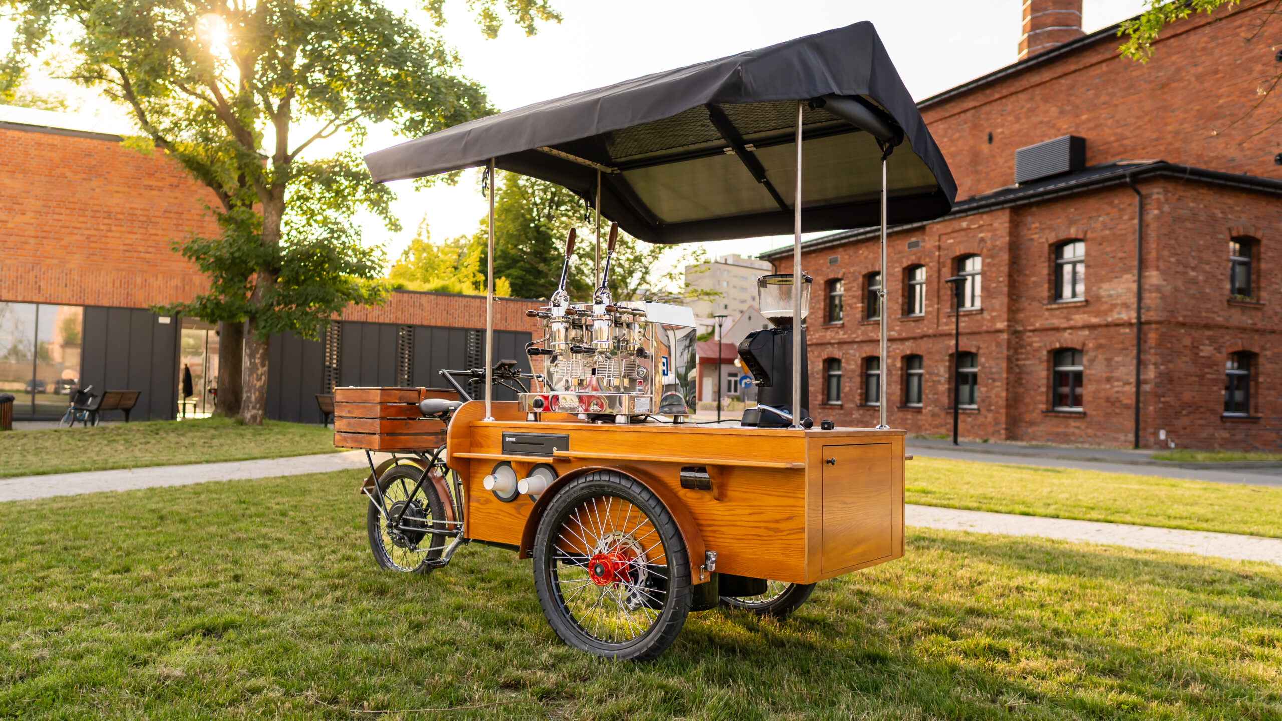 Elegancka riksza gastronomiczna BBS Bike w kolorze czarnym, zaadaptowana na mobilną kawiarnię "Kawa na Kołach". Wyposażona w profesjonalny blat z ekspresem do kawy, młynkiem i miejscem na akcesoria, gotowa do serwowania napojów w plenerze. Idealny food bike do mobilnej sprzedaży kawy.